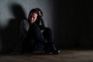 alternative treatment for depression, Sad mid-adult woman, alone in darkness, sitting and thinking