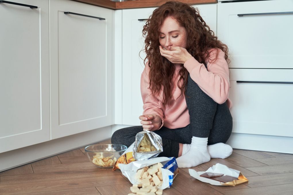 stress eating disorder, girl eating chips to deal with grief