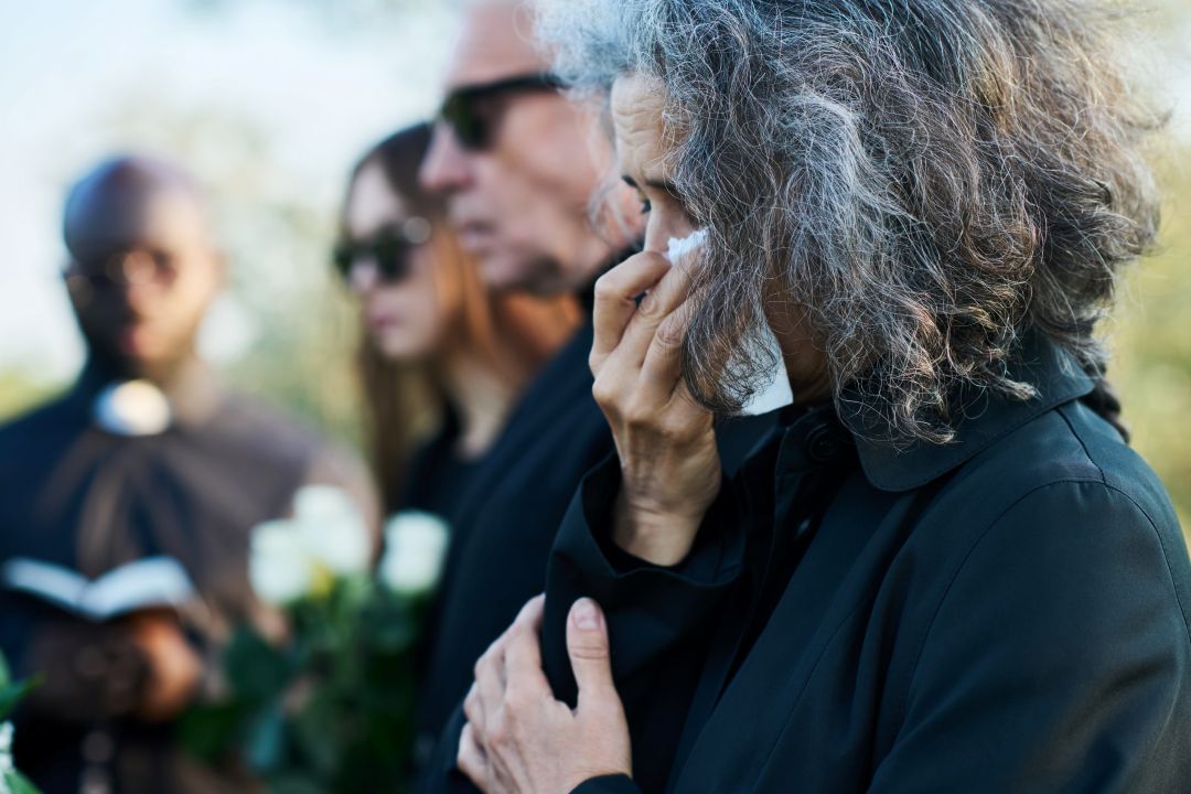 ways to deal with grief, a mother crying on her child's funeral